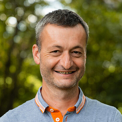 Mitarbeiterfoto vor grünem Hintergrund