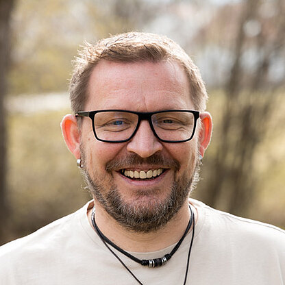 Mitarbeiterfoto vor grünem Hintergrund